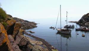 Outside of the protection of the jettys, yachts at anchor, floating on a calm sea that merges
with the sky.