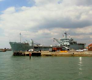 A naval supplies vessel undergoing refitting in H.M. Naval Base.