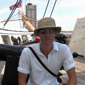 On deck, with the bowsprit behind me, flying the Union Flag