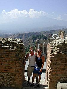 In the ruins of the Greek Theater in Taormina, Sicily. The huge mountain you can dimly see on the horizon is Mount Etna.